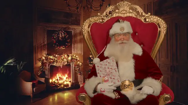 Santa in his red suit on a gold throne, holding a wrapped gift